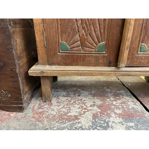 51 - An Indonesian carved teak two door cabinet - approx. 140cm high x 89cm wide x 35cm deep