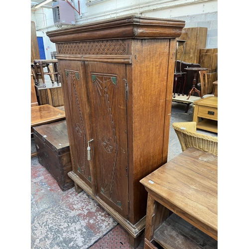 51 - An Indonesian carved teak two door cabinet - approx. 140cm high x 89cm wide x 35cm deep