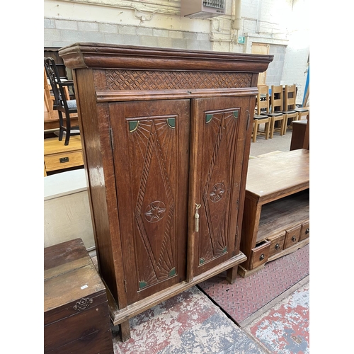 51 - An Indonesian carved teak two door cabinet - approx. 140cm high x 89cm wide x 35cm deep