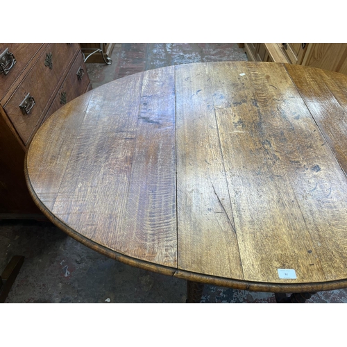 62 - An early 20th century oak drop leaf gate leg dining table on barley twist supports - approx. 73cm hi... 