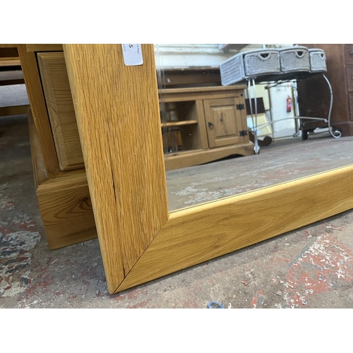 65 - A modern oak framed wall mirror - approx. 78cm high x 108cm wide