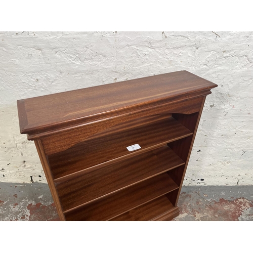 83 - A mahogany four tier wall mountable bookshelf - approx. 63cm high x 49cm wide x 13cm deep