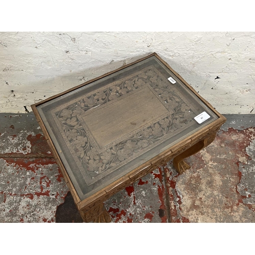 87 - An Indian carved teak side table with glass insert - approx. 38cm high x 41cm wide x 31cm deep