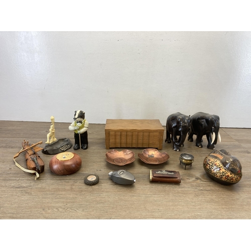 514 - A collection of items to include carved hardwood elephant figurines - approx. 13cm high, two copper ... 