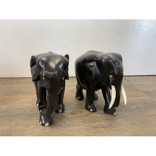 514 - A collection of items to include carved hardwood elephant figurines - approx. 13cm high, two copper ... 