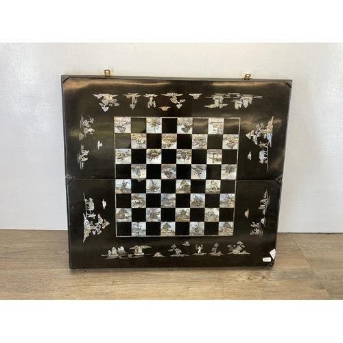 517 - A vintage Japanese black lacquered and mother of pearl inlaid folding travelling chess board - appro... 