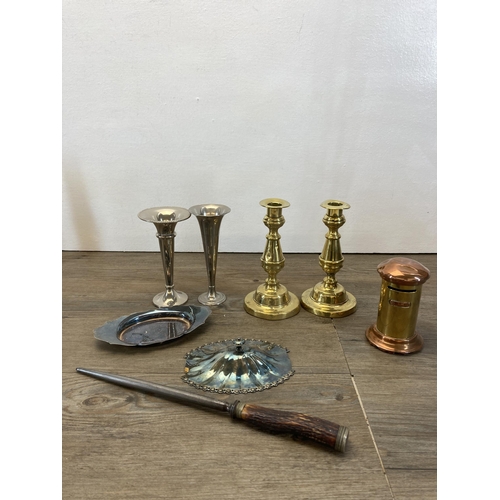 296 - A collection of metalware to include two pairs of brass candlesticks, brass chamber stick, brass lad... 