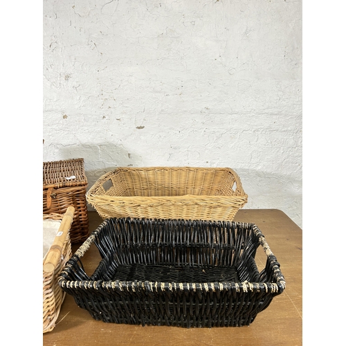 123 - Seven items, six wicker baskets and one vintage brown leather travel case