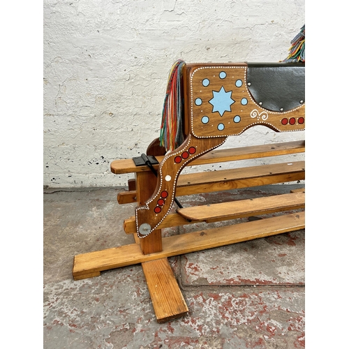 134 - A 1980s hand painted wooden rocking horse on pine stand - approx. 94cm high x 58cm wide x 147cm long