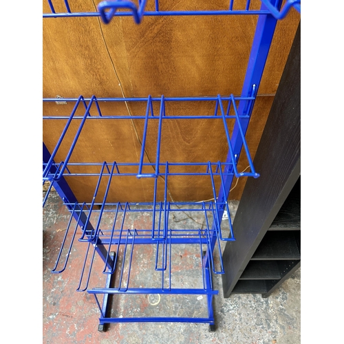 144 - Two items, one blue metal shop display rack and one black ash effect CD rack