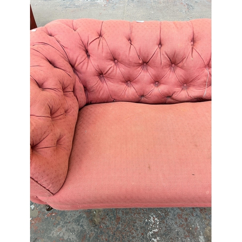 158 - A Victorian pink fabric button back upholstered sofa on turned mahogany supports and castors - appro... 