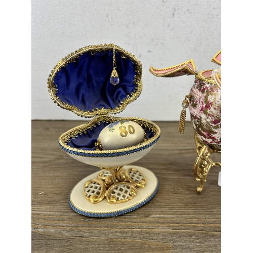 219 - Two hand painted and decorated duck egg trinket boxes on gilt metal stands - largest approx. 15cm hi... 