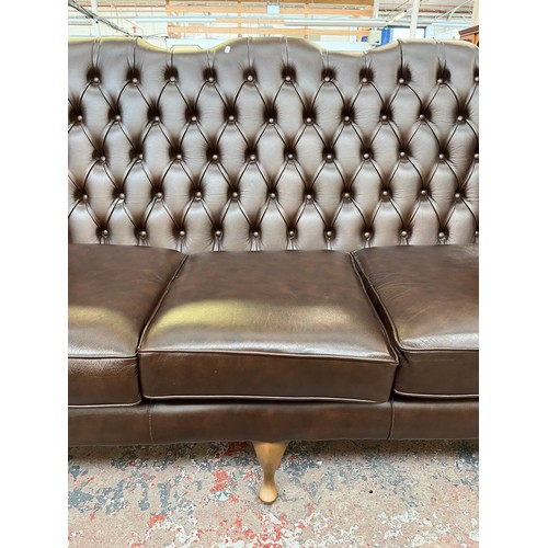 151A - A Buffalo brown leather Chesterfield wingback three seater sofa on cabriole supports - approx. 105cm... 