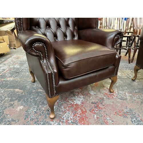 151B - A Buffalo brown leather Chesterfield wingback armchair on cabriole supports - approx. 103cm high x 9... 