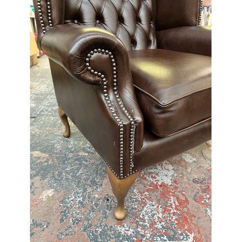 151B - A Buffalo brown leather Chesterfield wingback armchair on cabriole supports - approx. 103cm high x 9... 