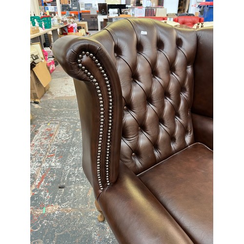 151B - A Buffalo brown leather Chesterfield wingback armchair on cabriole supports - approx. 103cm high x 9... 