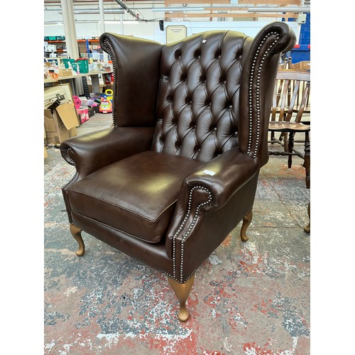 151B - A Buffalo brown leather Chesterfield wingback armchair on cabriole supports - approx. 103cm high x 9... 