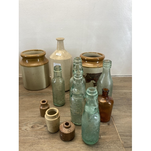 231 - A collection of antique glass bottles and stoneware vessels