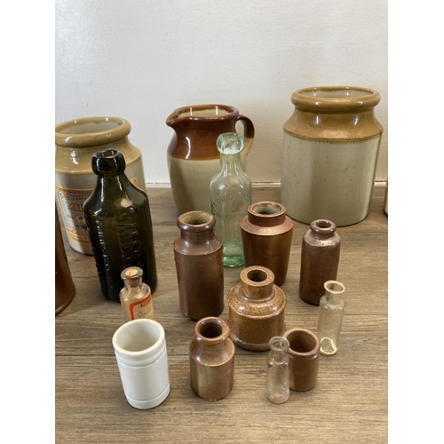 231 - A collection of antique glass bottles and stoneware vessels