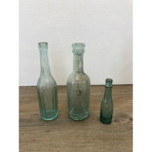 252 - A collection of antique glass bottles together with a ceramic pot lid