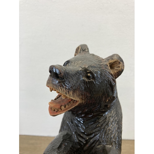 273 - A 19th century Black Forest carved bear in standing position with arms raised - approx. 33cm high