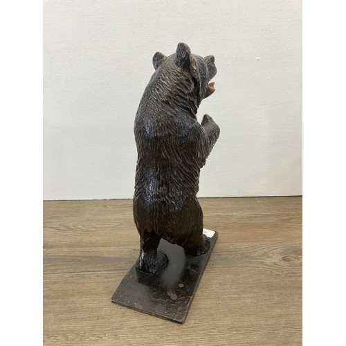 273 - A 19th century Black Forest carved bear in standing position with arms raised - approx. 33cm high