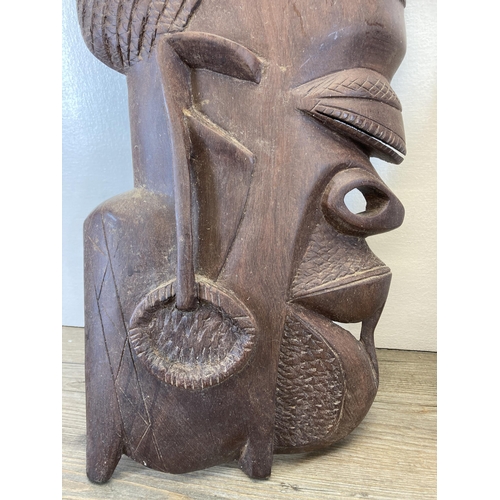 280 - A pair of African Tribal style carved hardwood wall masks - approx. 62cm high x 25cm wide