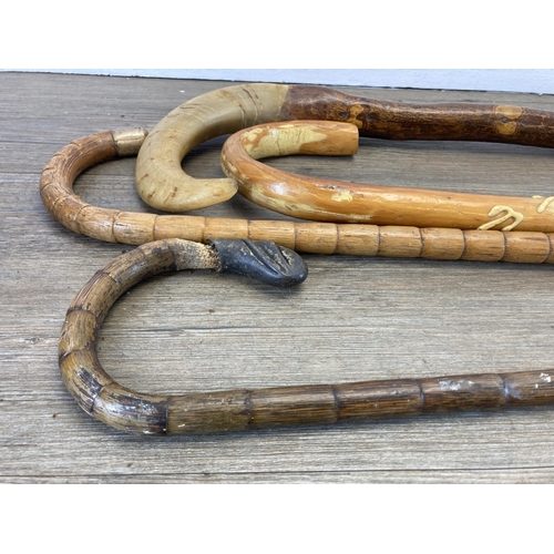 290 - Five 19th century and later walking sticks to include horn handled, carved ebony with 18ct gold plat... 