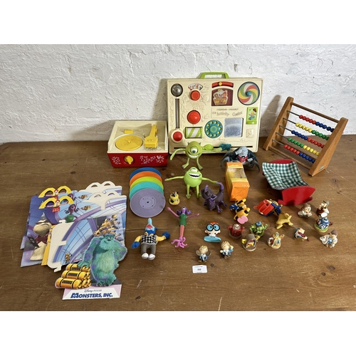 332 - A collection of toys to include a vintage Fisher Price Activity Center, Monster Inc figurines, Fishe... 