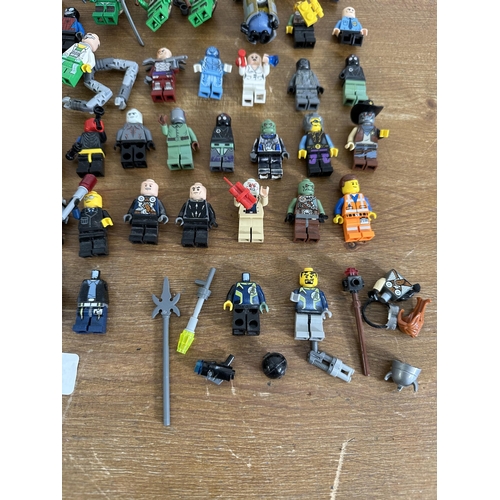 337 - A collection of film and superhero related Lego figurines to include Ironman, Batman, Indiana Jones,... 