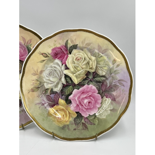 217 - Two 1980s Reginald Johnson hand painted porcelain plates depicting flowers - approx. 26cm diameter