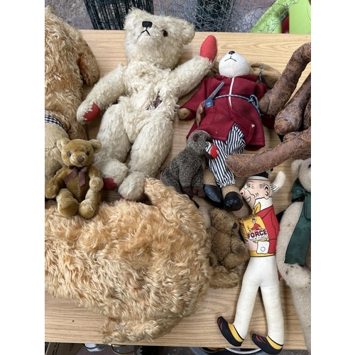 363 - A collection of soft toys to include mid 20th century articulated teddy bear, Aurora Teddy freestand... 