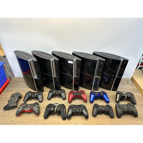 668 - A box containing five Sony PlayStation 3 consoles and controllers