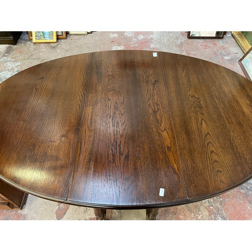 22 - A mid 20th century oak drop leaf gate leg oval dining table - approx. 75cm high x 90cm wide x 146cm ... 