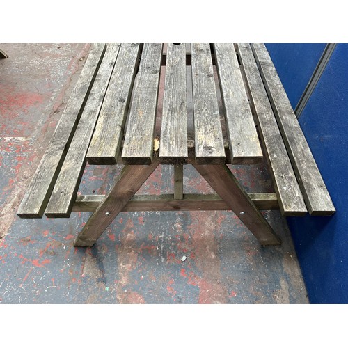 129 - A wooden picnic bench - approx. 75cm high x 127cm wide x 149cm long