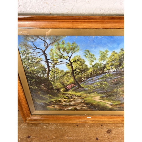 198 - An early 20th century framed oil painting of a woodland scene, signed lower left - approx. 65cm high... 