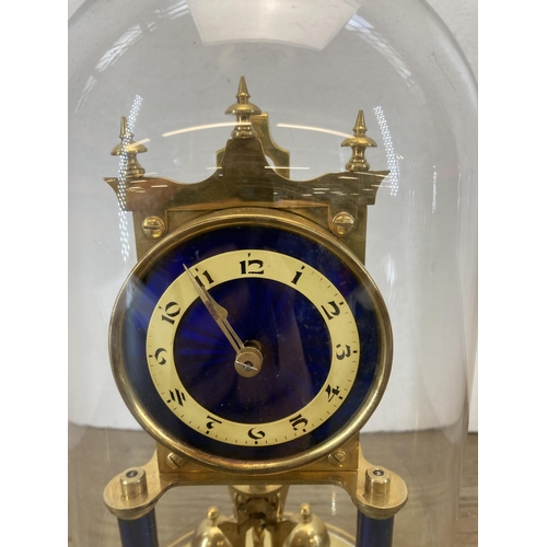 556 - An early 20th century blue enamel and brass 400-day German Torsion mantel clock with glass dome