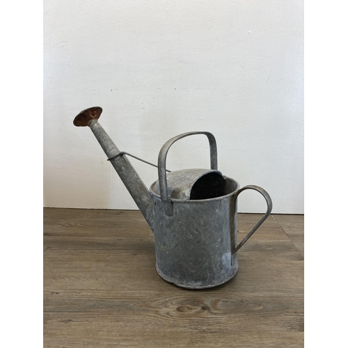 327A - Three pieces of metalware, two mid 20th century galvanised watering cans and one Shell Motor Spirit ... 