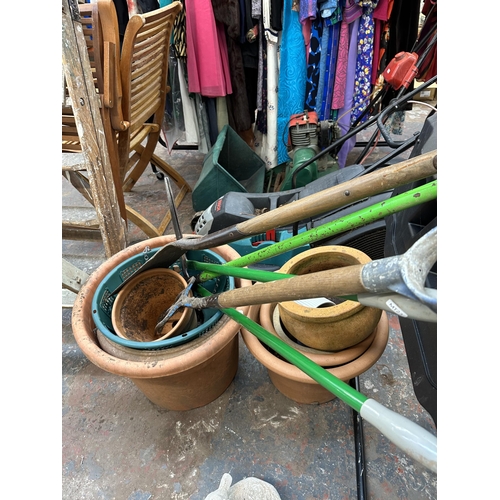 869 - A collection of garden items to include compost mixer, terracotta planters, spade etc.