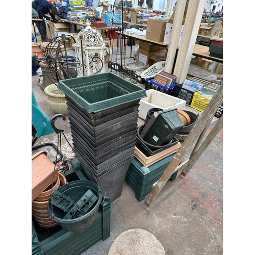 870 - A large quantity of plastic garden planters together with a 240v garden strimmer and a 240v garden v... 