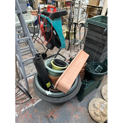 870 - A large quantity of plastic garden planters together with a 240v garden strimmer and a 240v garden v... 