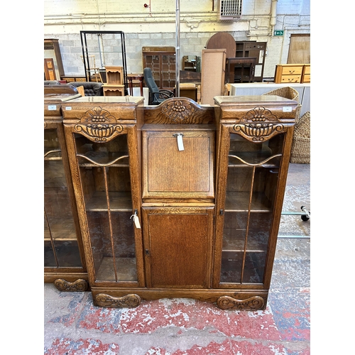 105 - An Art Deco style carved oak side by side bureau bookcase - approx. 123cm high x 106cm wide x 29cm d... 