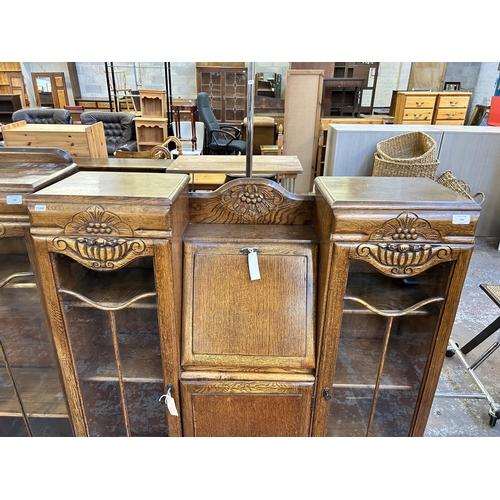 105 - An Art Deco style carved oak side by side bureau bookcase - approx. 123cm high x 106cm wide x 29cm d... 