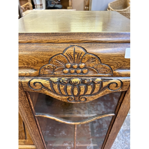 105 - An Art Deco style carved oak side by side bureau bookcase - approx. 123cm high x 106cm wide x 29cm d... 