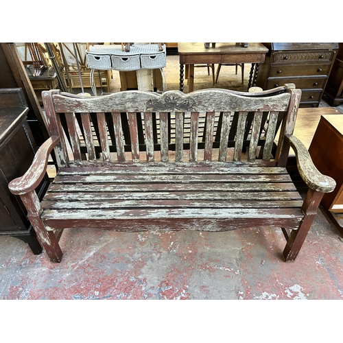 113 - A carved teak garden bench - approx. 90cm high x 158cm wide x 58cm deep