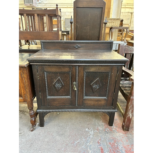 115 - An early 20th century carved oak two door cabinet with fitted interior - approx. 93cm high x 91cm wi... 