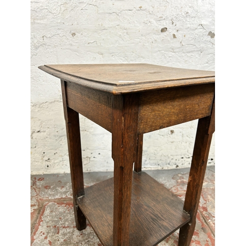 140 - An Arts & Crafts oak two tier side table - approx. 64cm high x 45cm wide x 44cm deep