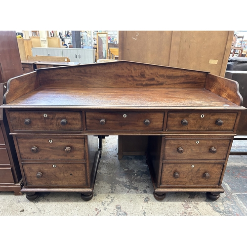 19 - A Victorian mahogany writing desk with galleried back and seven drawers - approx. 110cm high x 165cm... 