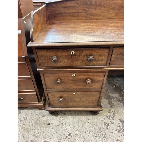 19 - A Victorian mahogany writing desk with galleried back and seven drawers - approx. 110cm high x 165cm... 