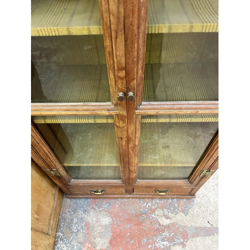 23 - A Georgian oak glazed two door bookcase with two lower drawers - approx. 120cm high x 63cm wide x 27... 